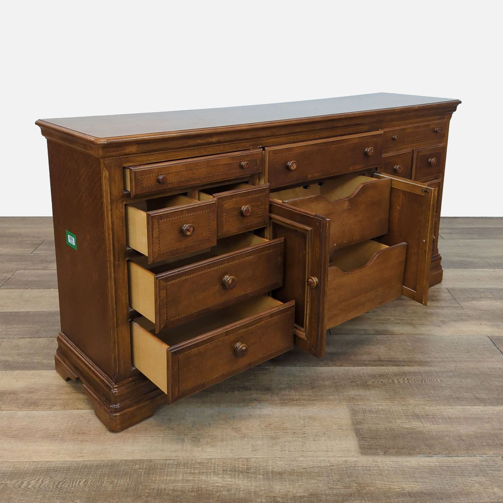 Side view of cherry wood dresser by Alexander Julian, showcasing open drawers and ample storage.