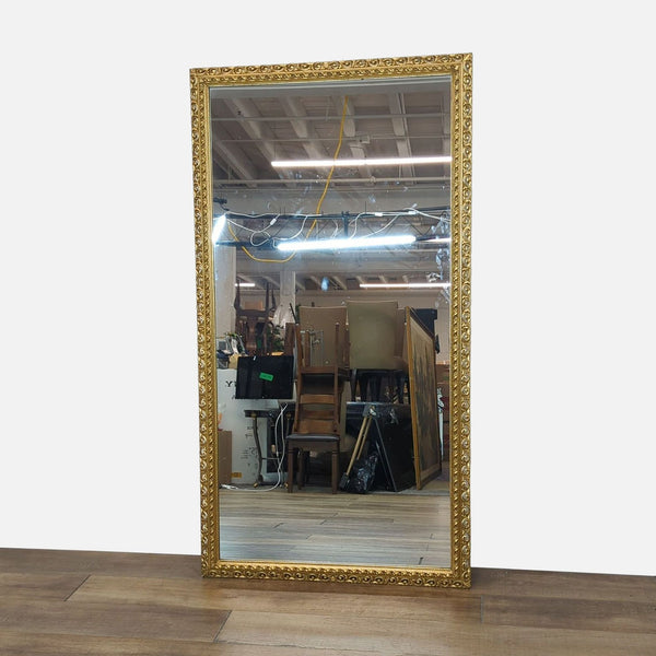 Gold-framed Reperch mirror with intricate detailing, reflecting a cluttered interior setting.