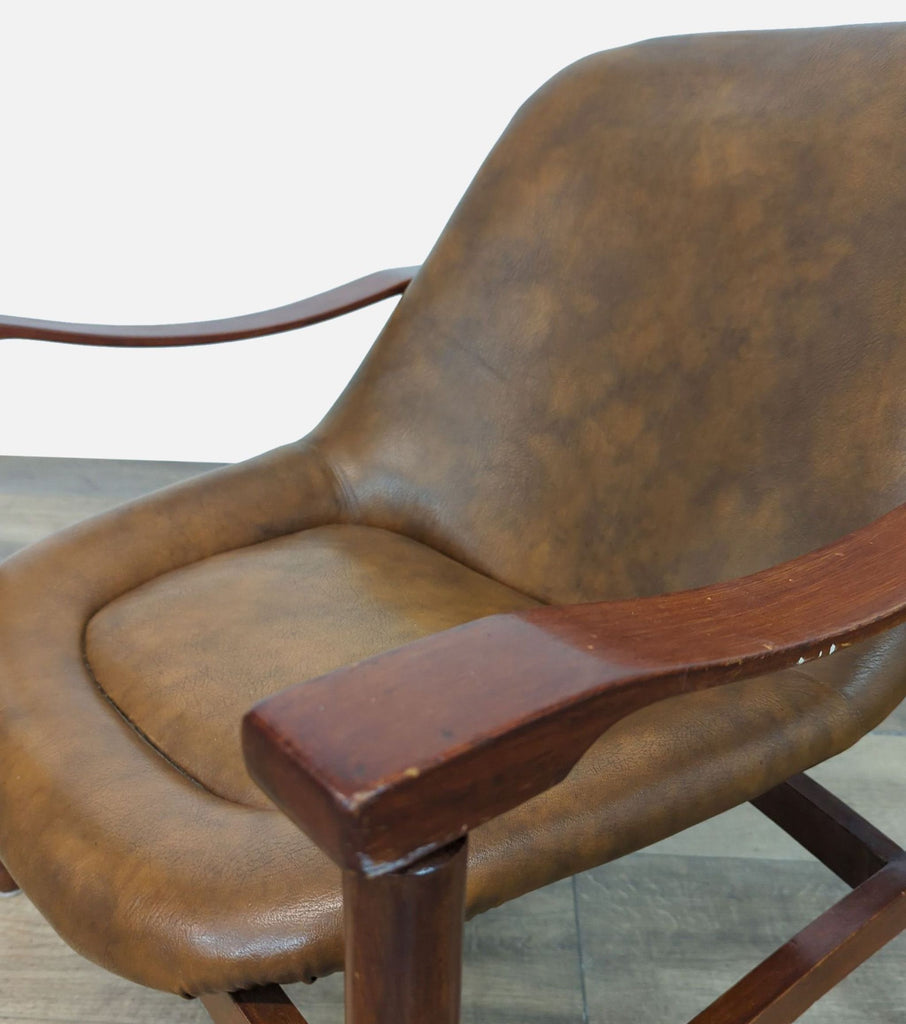 Close-up of 1950s Busnelli chair armrest, featuring brown wood and leather upholstery.