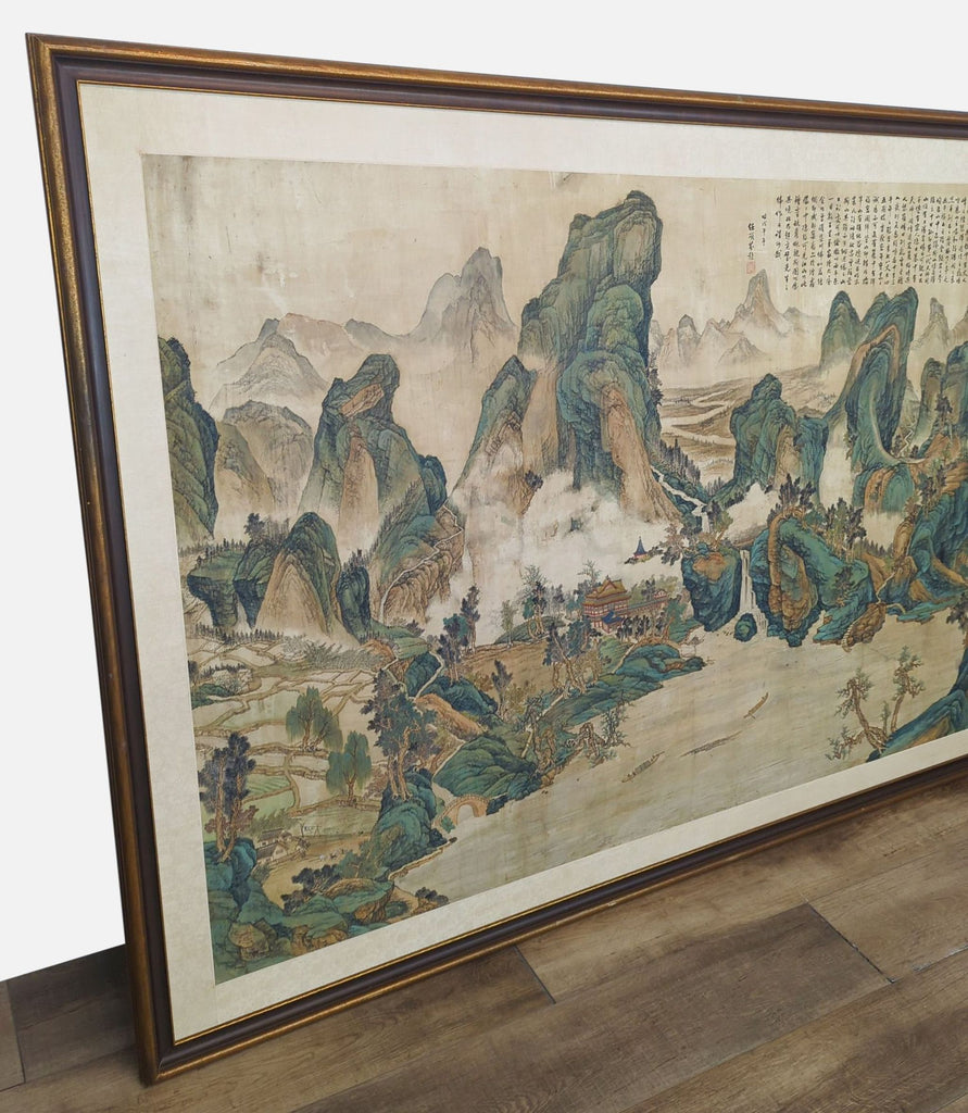 Close-up of a large Chinese scroll showing intricate mountain scenery, framed elegantly.
