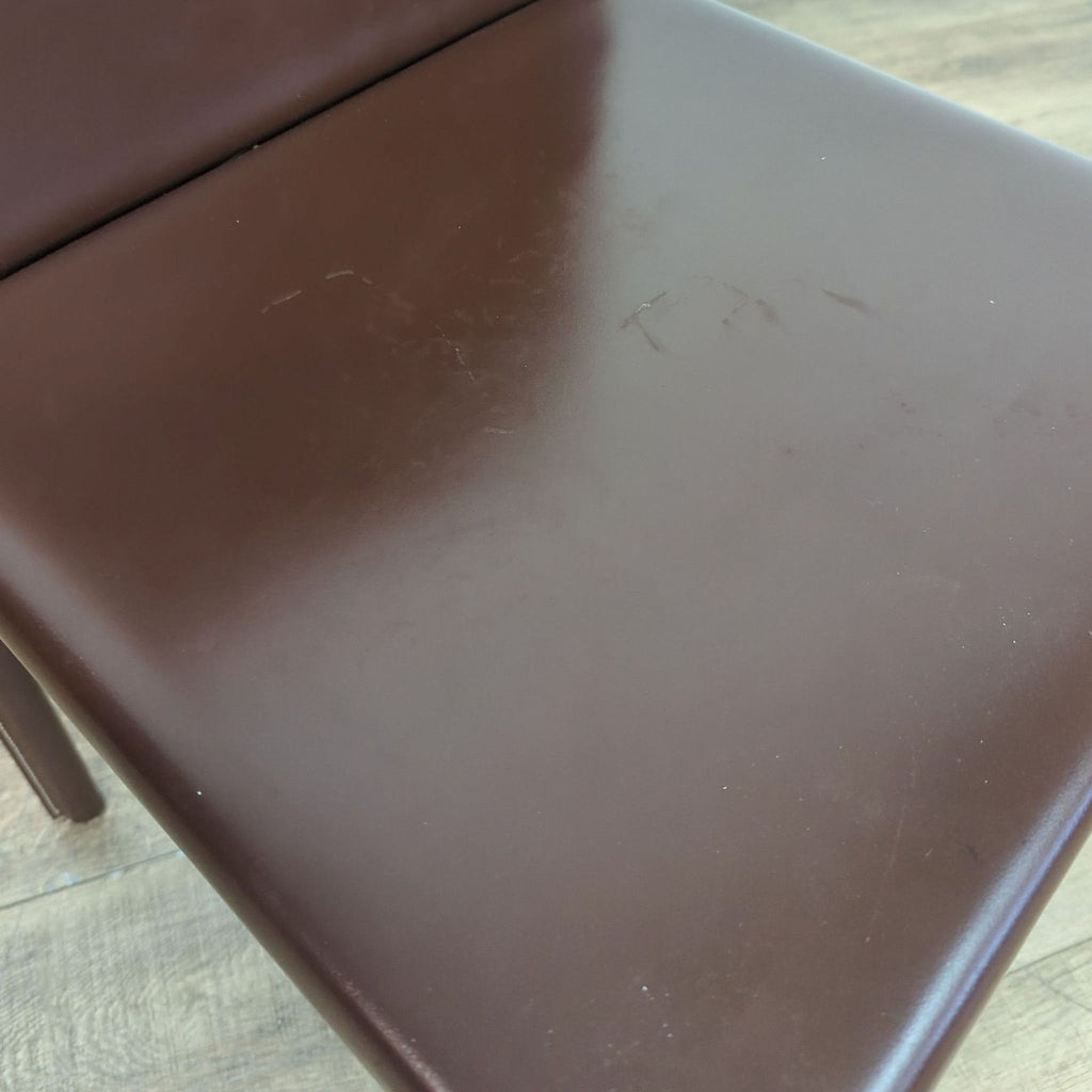 Detailed view of the Reperch chair’s leather seat, showing the smooth finish and subtle stitched seams.