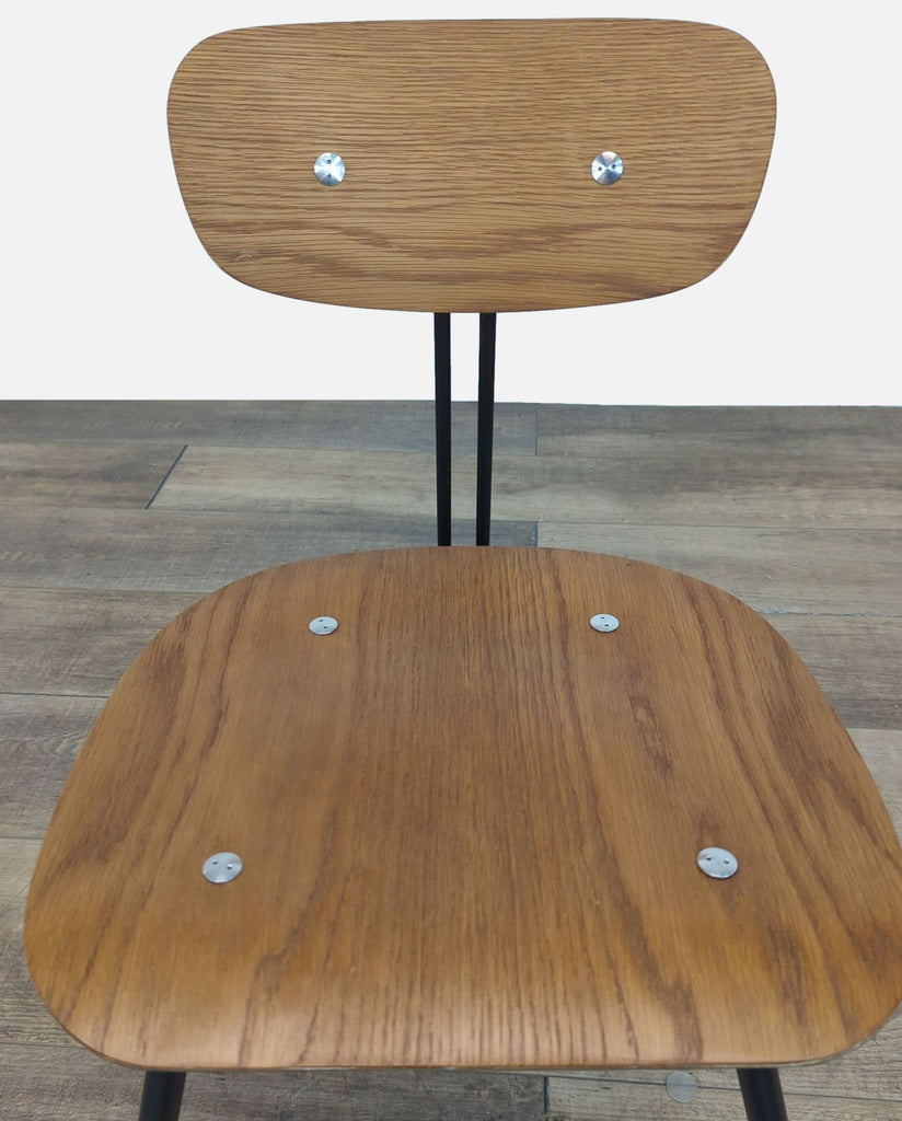 Close-up of the wooden seat and backrest of the Eames style chair.