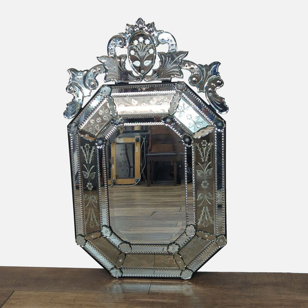 Ornate octagonal mirror with decorative floral border and intricate top detailing.