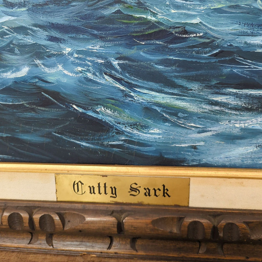 Detail of the ornate frame's brass plate labeled "Cutty Sark" beneath the nautical painting.