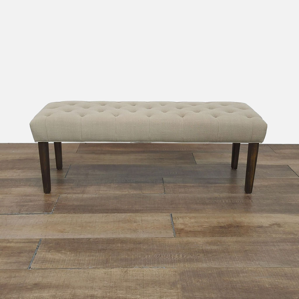 Tufted fabric bench with wood legs, perfect for seating.