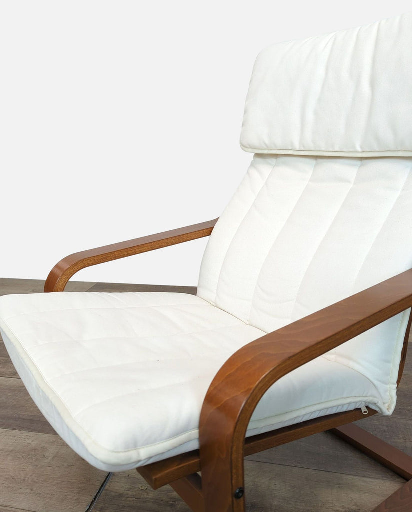 Close-up of IKEA POÄNG chair showing wooden armrests and removable white cover.