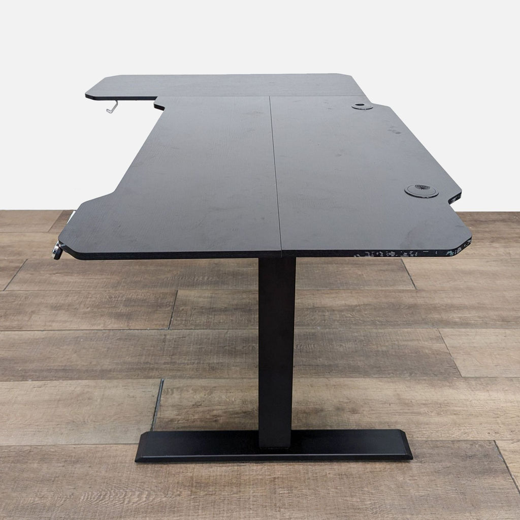 Black L-shaped desk by Reperch featuring programmable height and cord management.