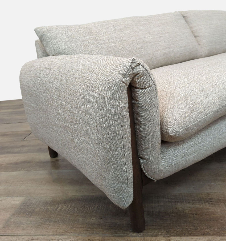 Close-up of Reperch sofa's arm and upholstery highlighting its soft texture and elegant wooden legs.