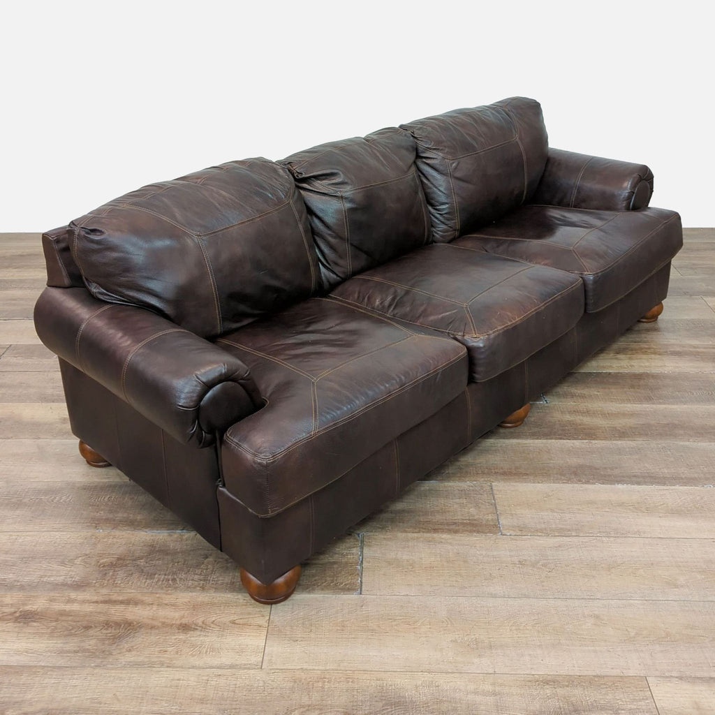 Reperch 3-seat leather sofa featuring plush cushions, rolled arms, and wooden feet.