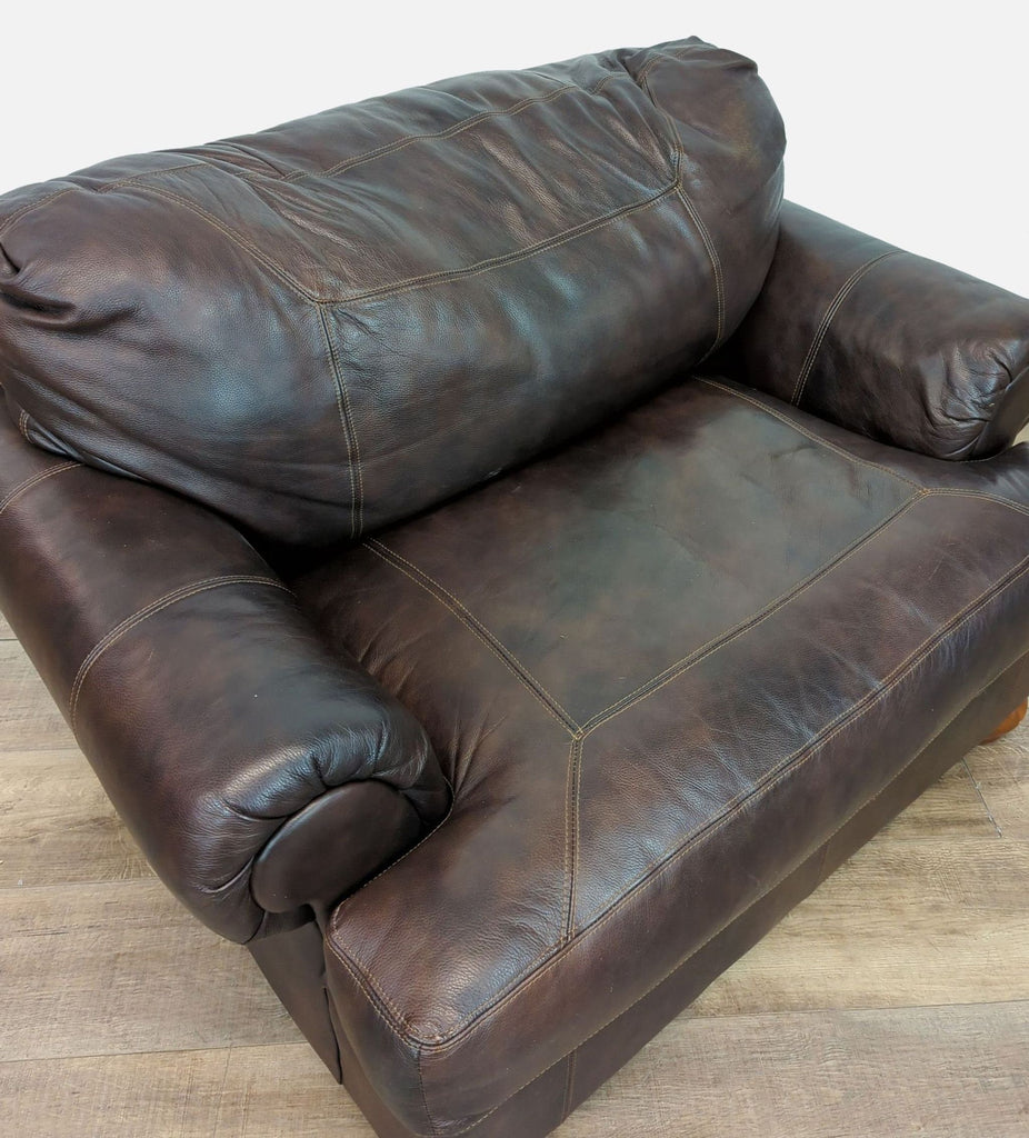 Ashley Furniture lounge chair in brown leather, featuring rolled arms and wood feet.
