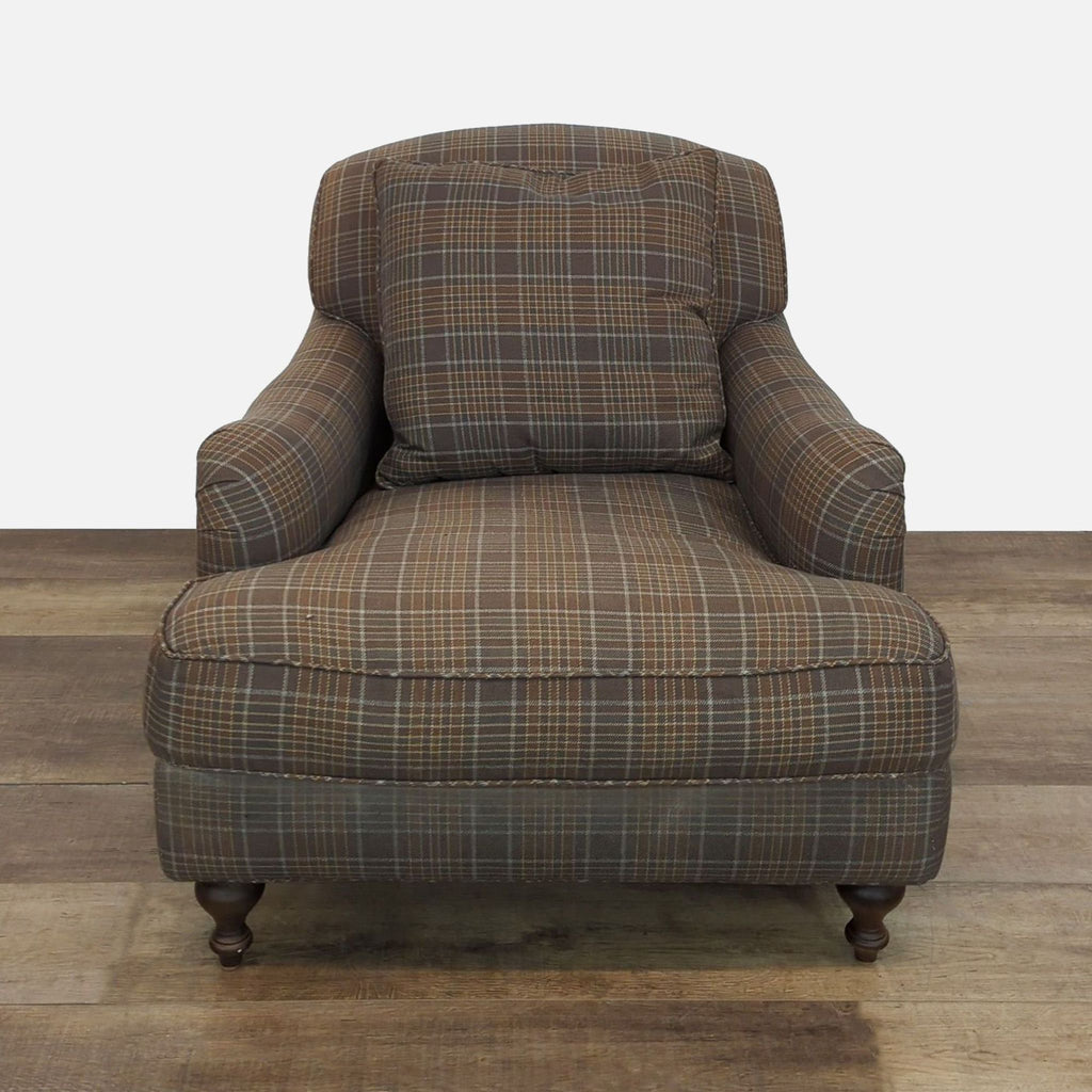 Plaid lounge chair with turned wood legs and loose back cushion.