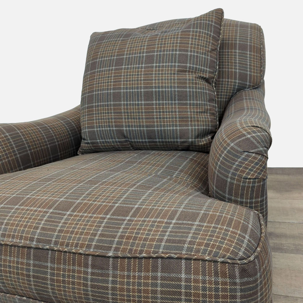 Close-up of plaid upholstery and loose cushion on lounge chair.