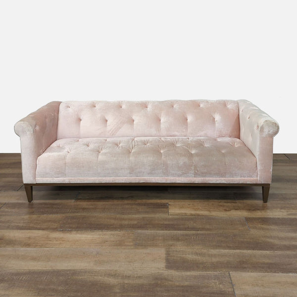 Soft pink 3-seat sofa with button tufting and rolled arms, by Anthropologie.