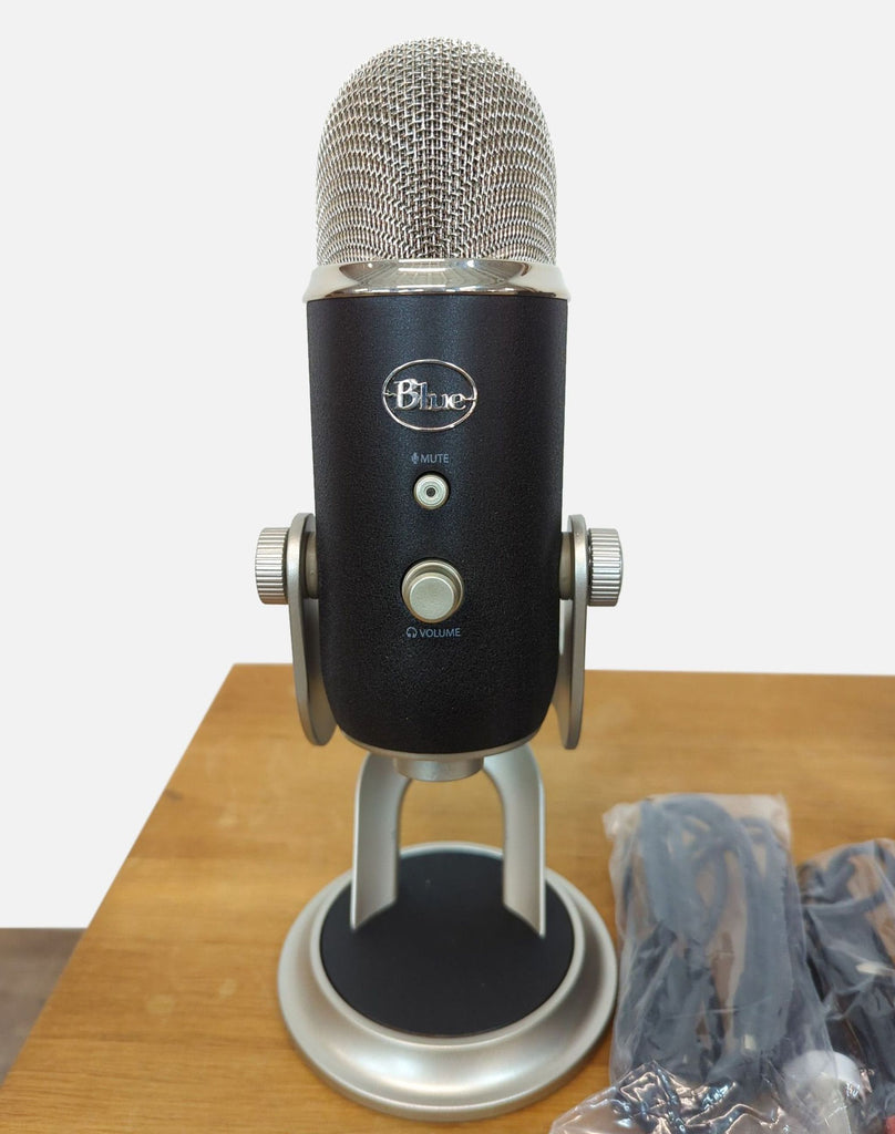 Close-up of the Blue Yeti Pro microphone with cables on a wooden surface.