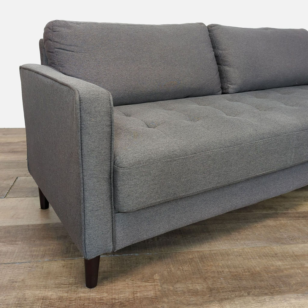 Close-up of the armrest and cushion detailing on the gray loveseat by Lifestyle Solutions.