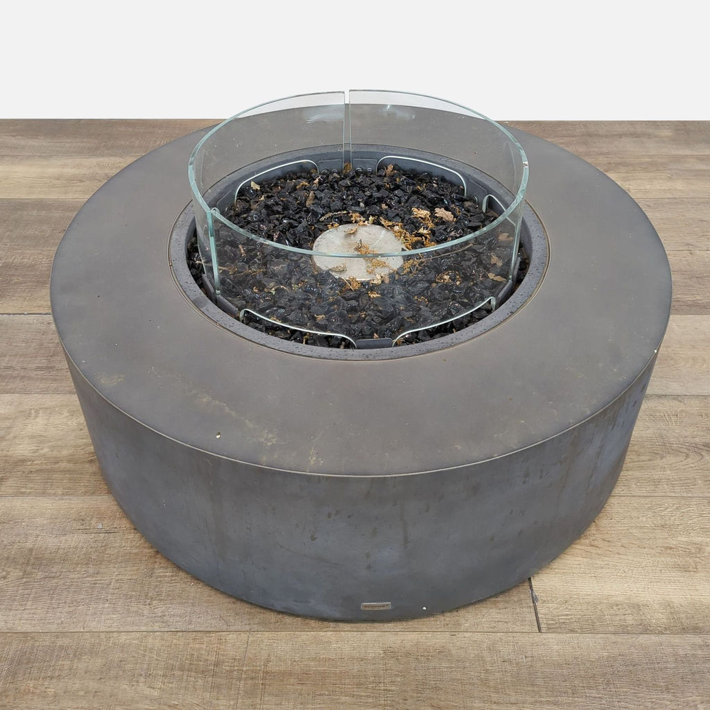 Circular EcoSmart fire pit featuring adjustable feet on wooden surface.