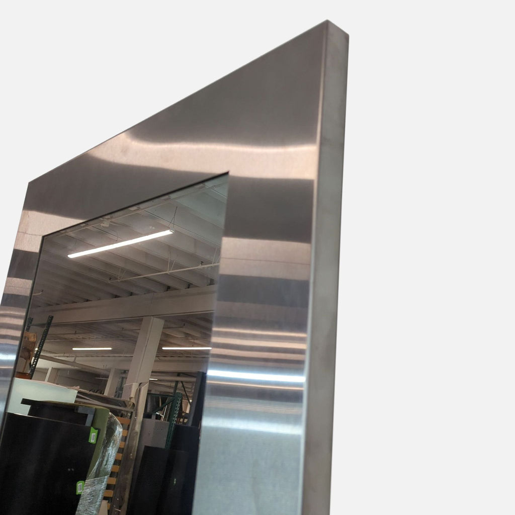 Close-up of the metallic frame of a mirror, emphasizing its sleek, modern design.