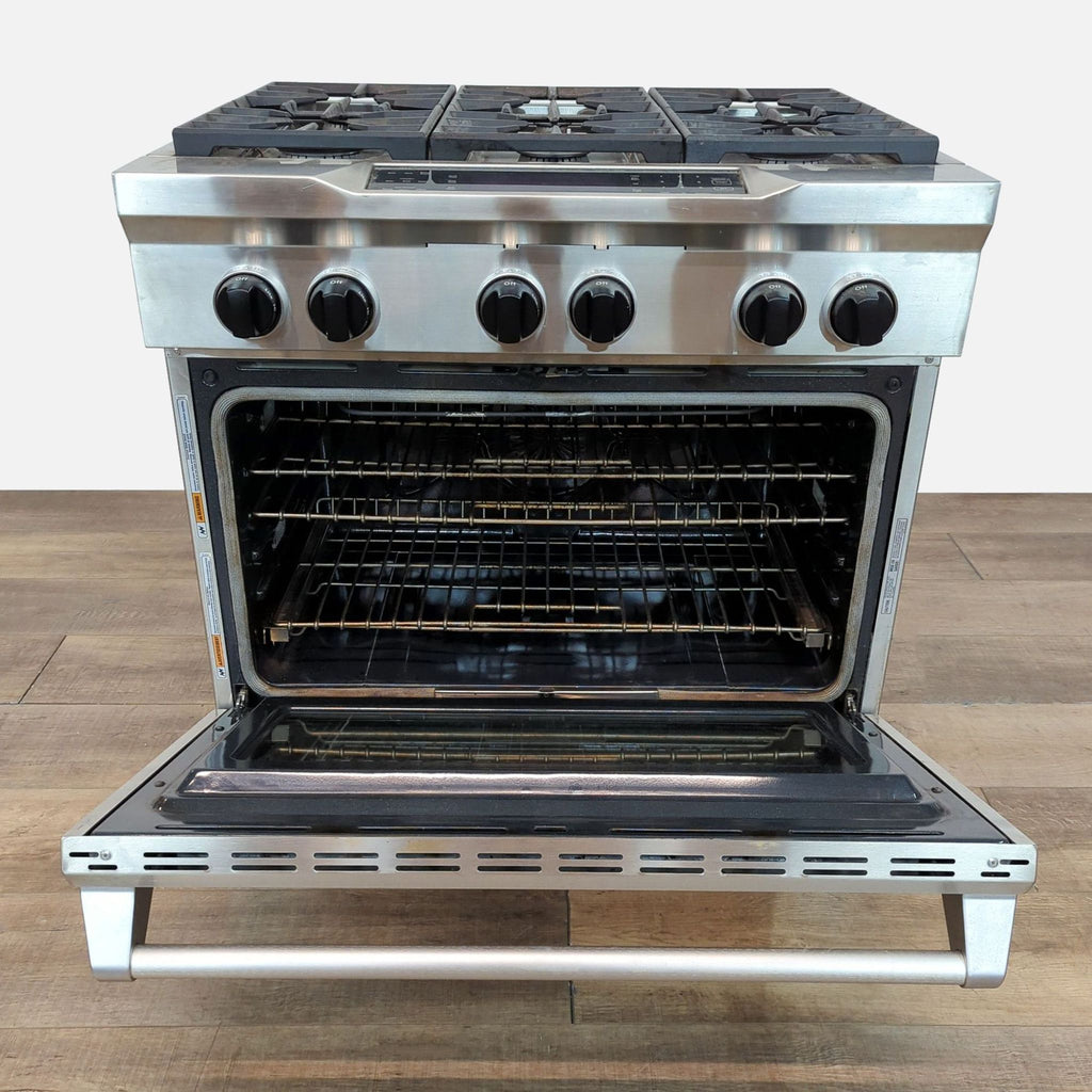 Stainless steel KitchenAid stove, four burners, large oven with the door open, modern look.
