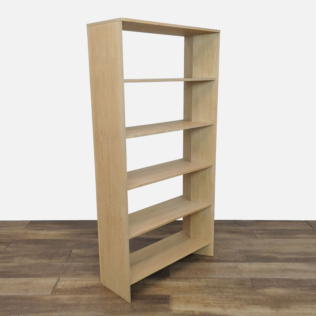 Side view of a solid oak bookshelf featuring an ivory ceruse finish by Crate & Barrel.