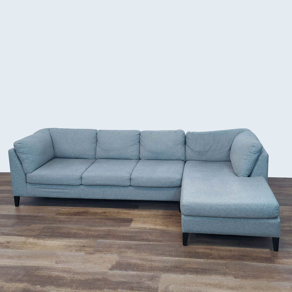 EQ3 sectional sofa with fabric upholstery and tapered legs. 