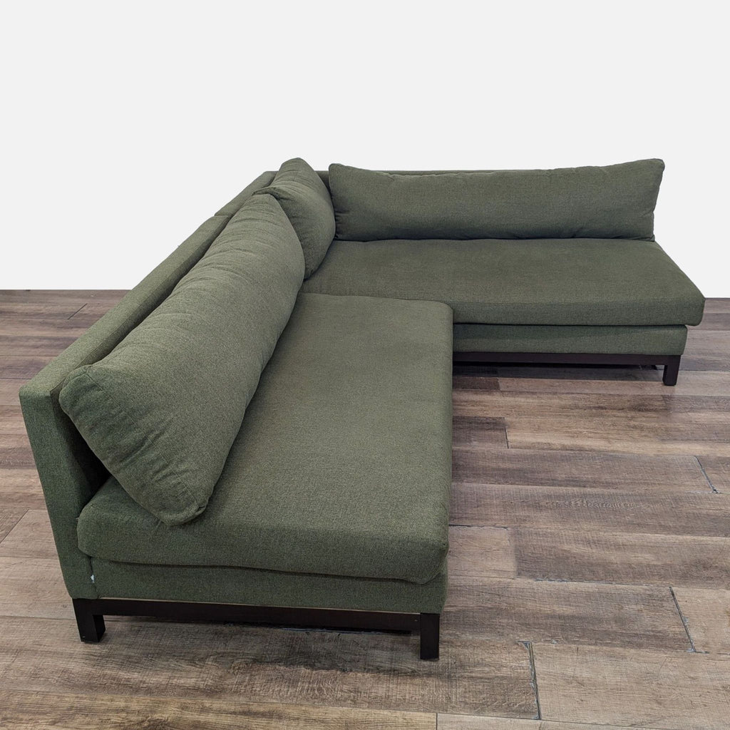 Arwen corner sectional featuring plush, olive upholstery with a wooden base.