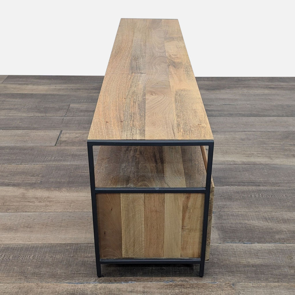 Side view of mango wood entertainment center with sleek blackened steel legs.