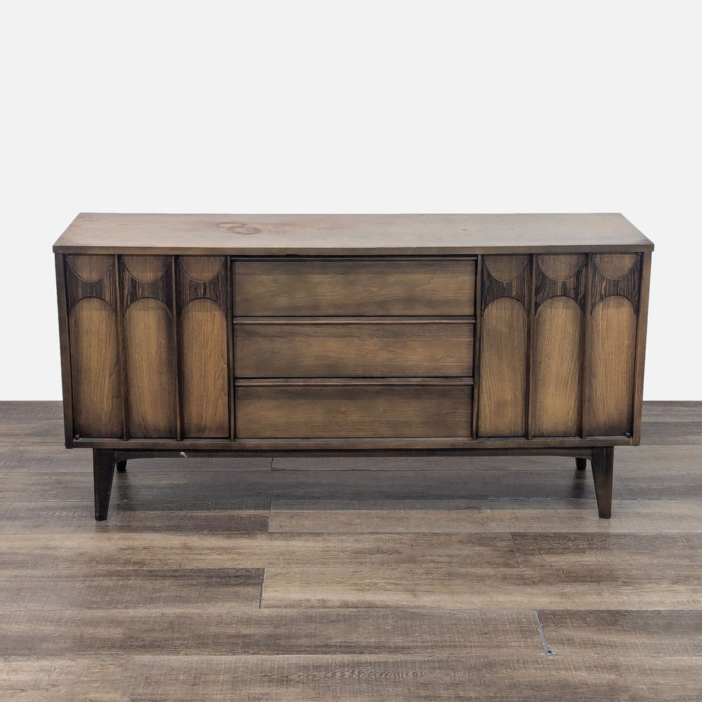 Reperch sideboard with three central drawers, flanked by decorative vertical panels.