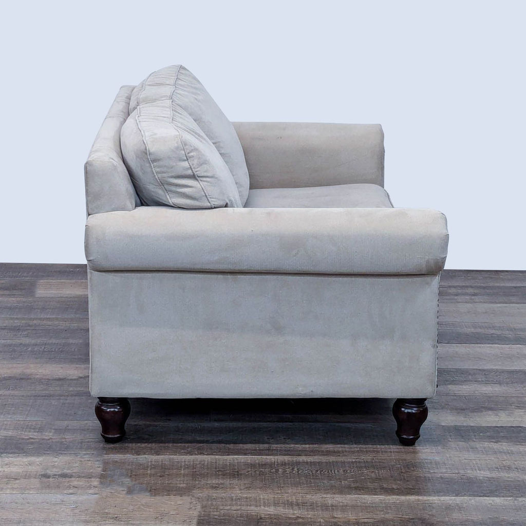 Side view of Bauhaus loveseat showcasing its rolled arms and turned feet.