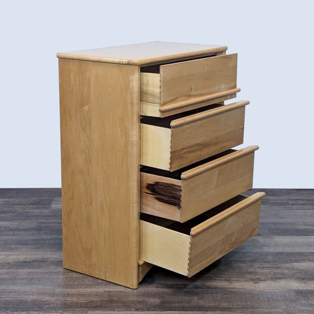 Side angle of natural wood dresser with four open drawers and dovetail joinery.
