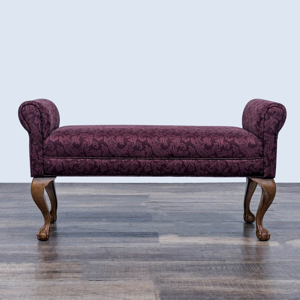 Purple upholstered bench with rolled arms and cabriole legs ending in paw feet.