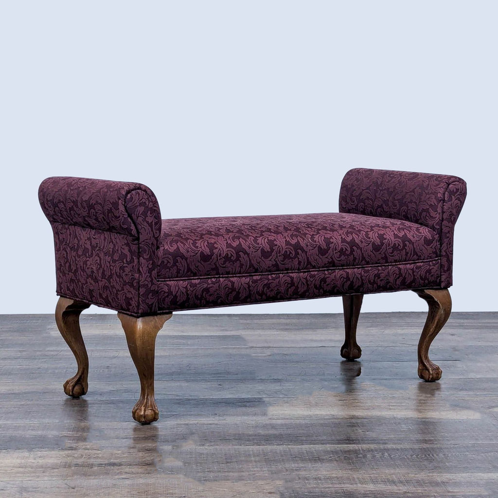 Side view of a stylish bench with ornate legs and patterned upholstery in rich purple.