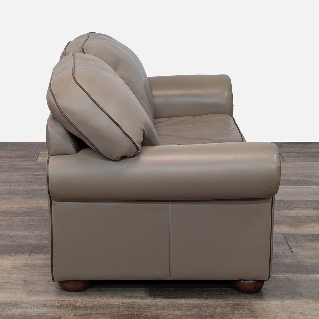 Side view of Reperch loveseat in taupe leather with wood feet.