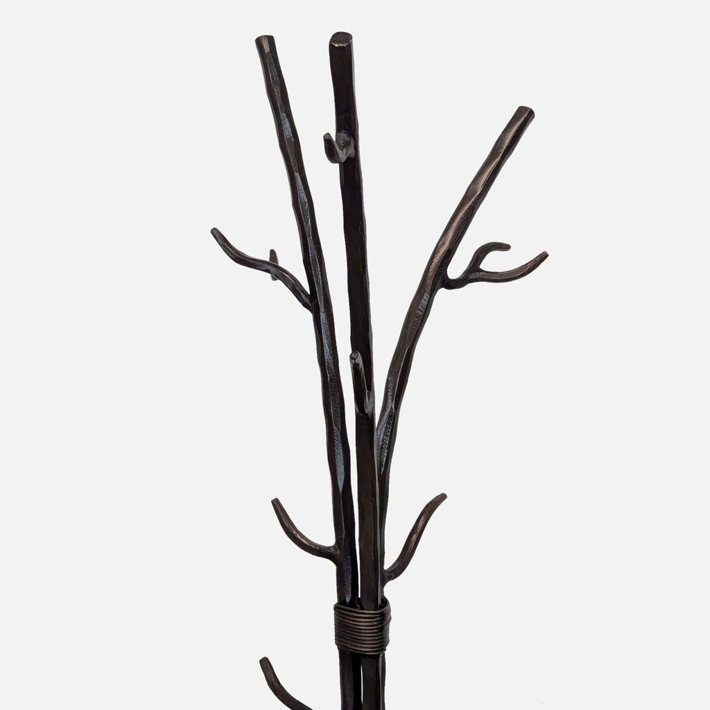 Close-up of the top section of a metal coat rack with curved hooks.