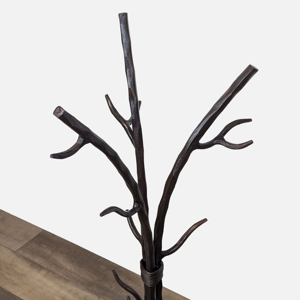 Angled view of metal coat rack's top, showing branch-style design.