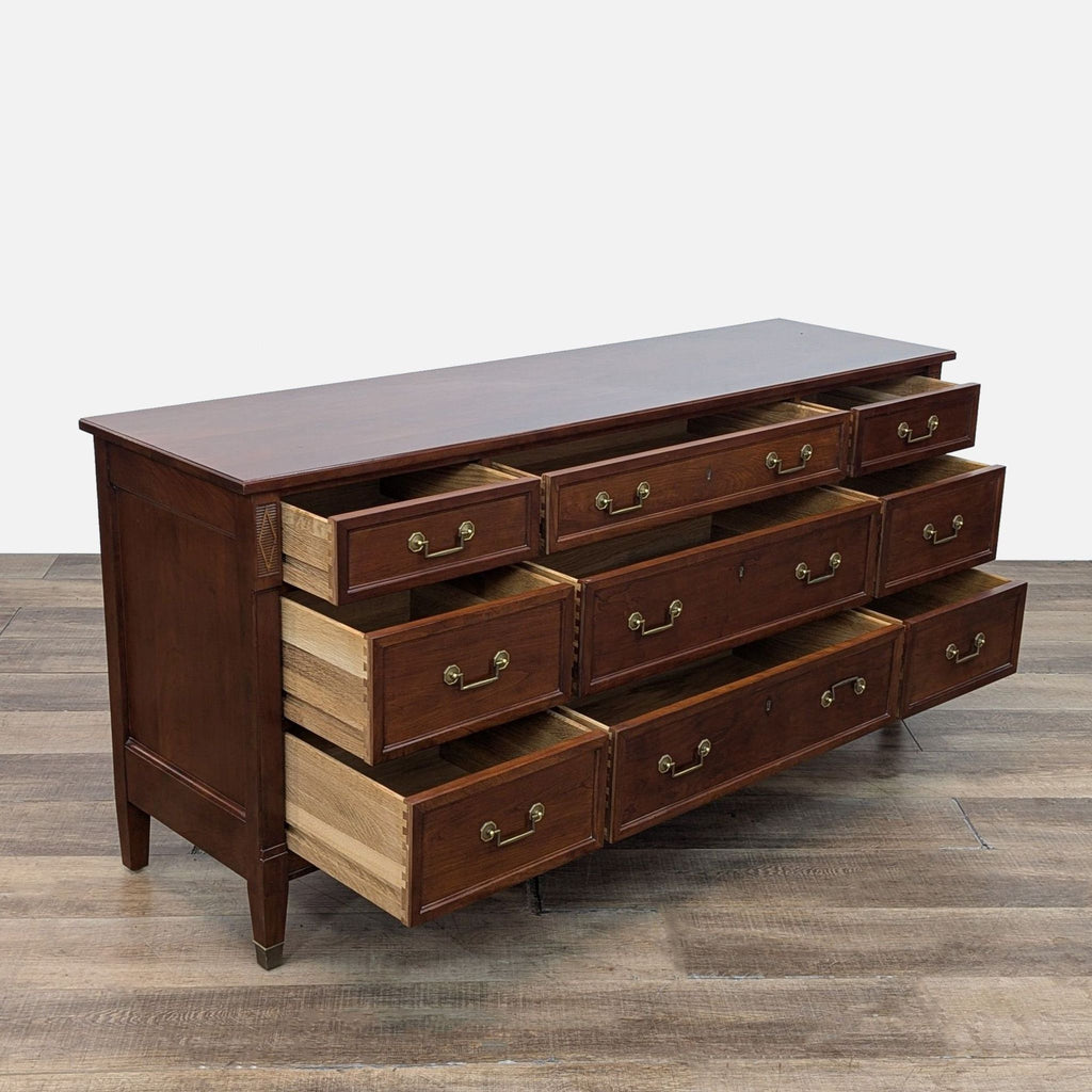 Side view of cherry wood dresser with open drawers and brass handles.