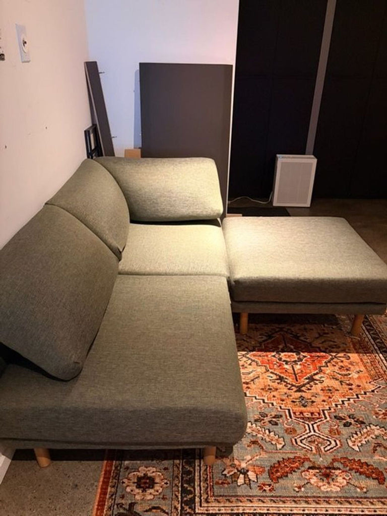 1. Reperch 3-seat sofa in olive green fabric with wooden legs, L-shaped arrangement, placed on a patterned rug.