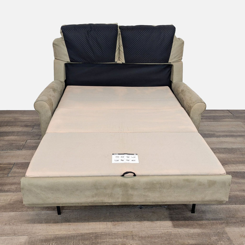 Sleeper sofa extended into a bed with visible handle.