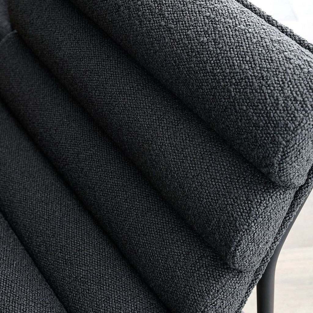 Close-up of Vail Counter Stool's charcoal boucle channel-tufted upholstery.