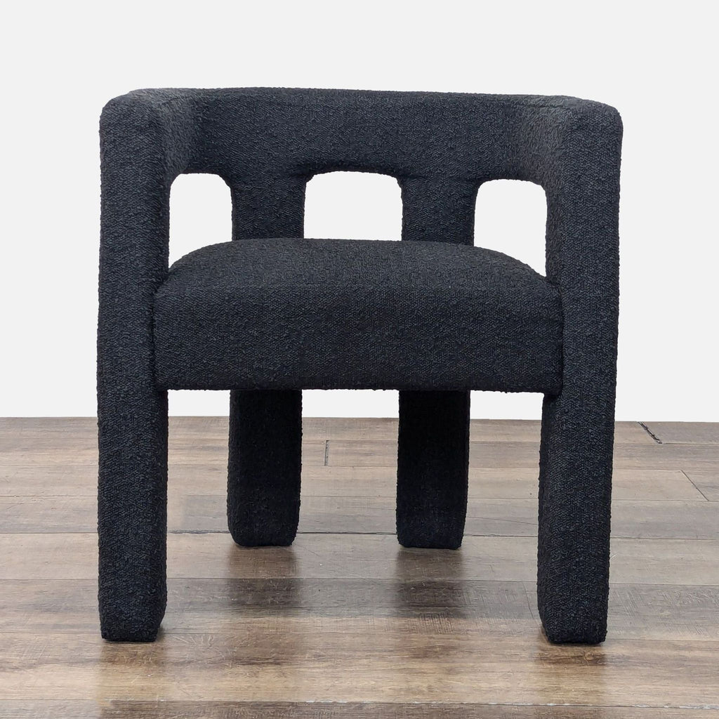 Front view of a modern dining chair with boucle fabric in black.