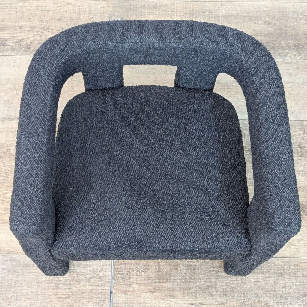 Top view of a dining chair, showcasing its curved design and boucle texture.
