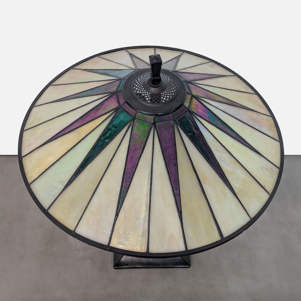Art glass lamp shade in a triangular pattern of warm colors, top view.