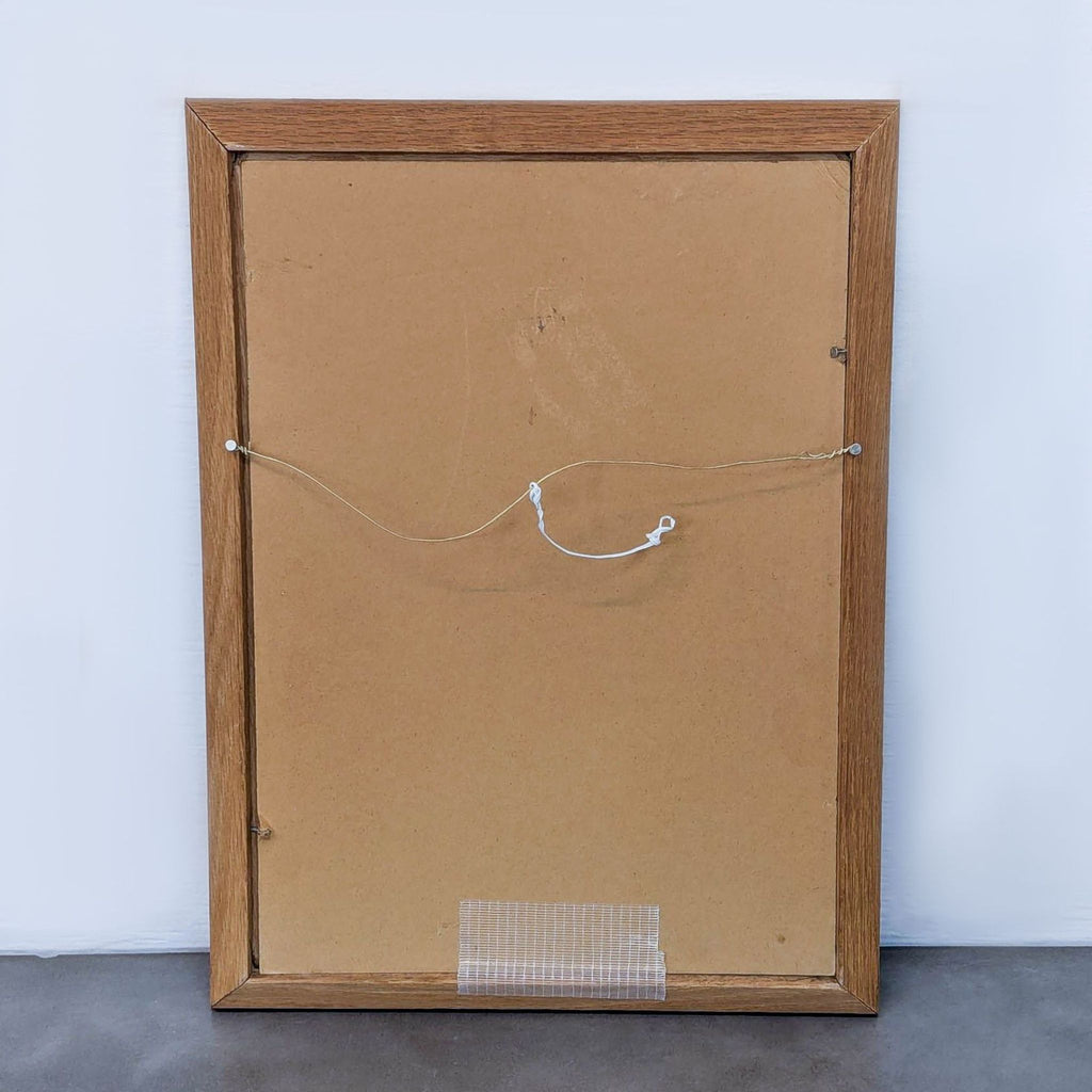Back view of framed painting showing wooden frame and hanging wire.