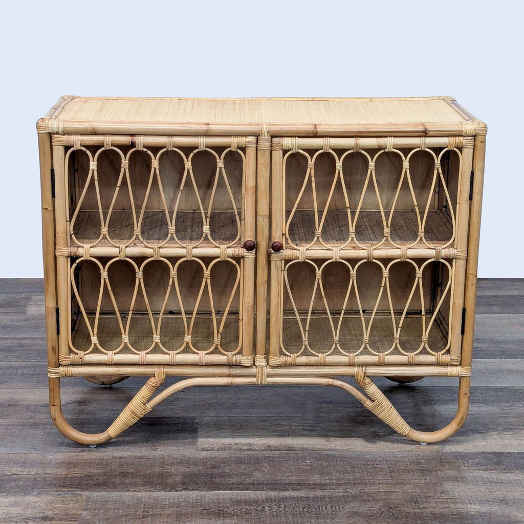 Two-door rattan cabinet with curving base and intricate design.