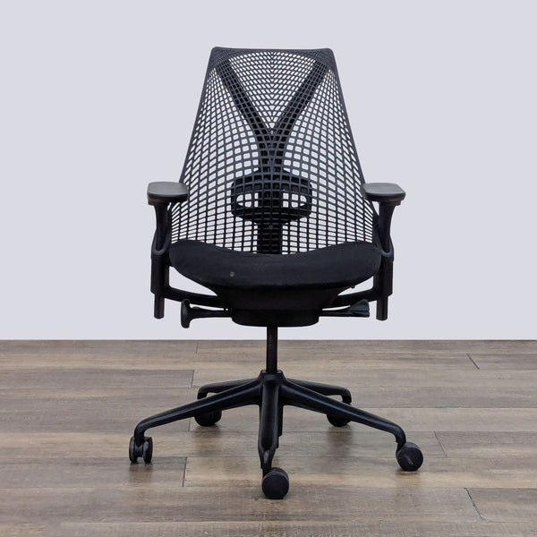 Front view of a Sayl chair with a mesh back and cushioned seat, set on a wooden floor.