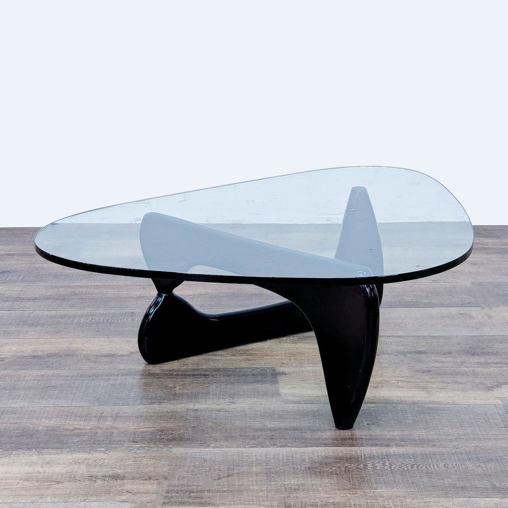 Noguchi table with glass top and curved wooden base, modern design by Herman Miller.