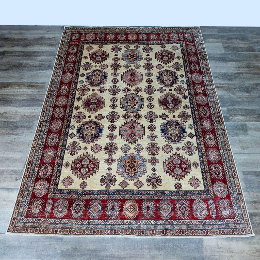 Hand-knotted wool rug with intricate red and beige patterns, Reperch brand.
