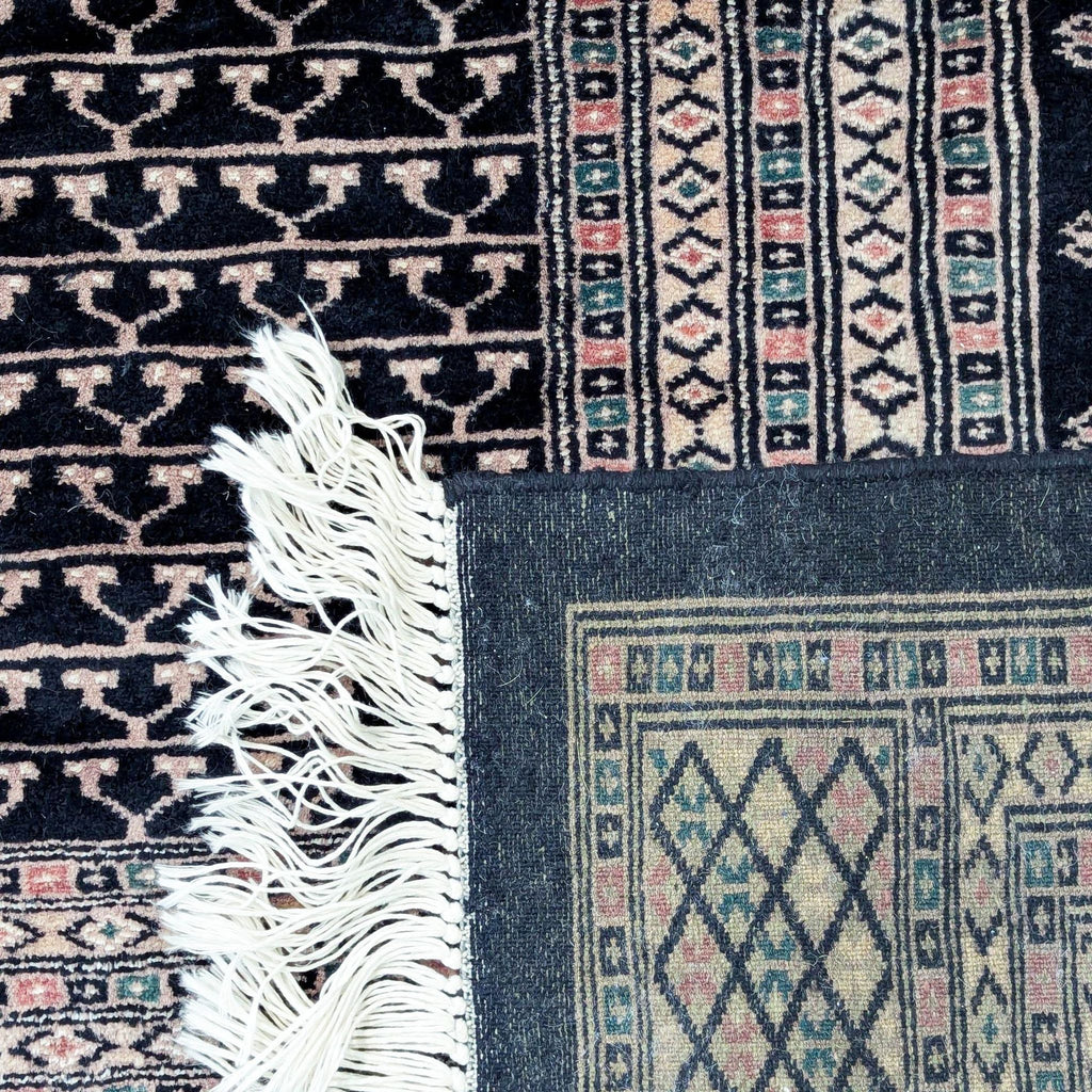 Intricate pattern detail of a Pakistani wool rug with fringe.
