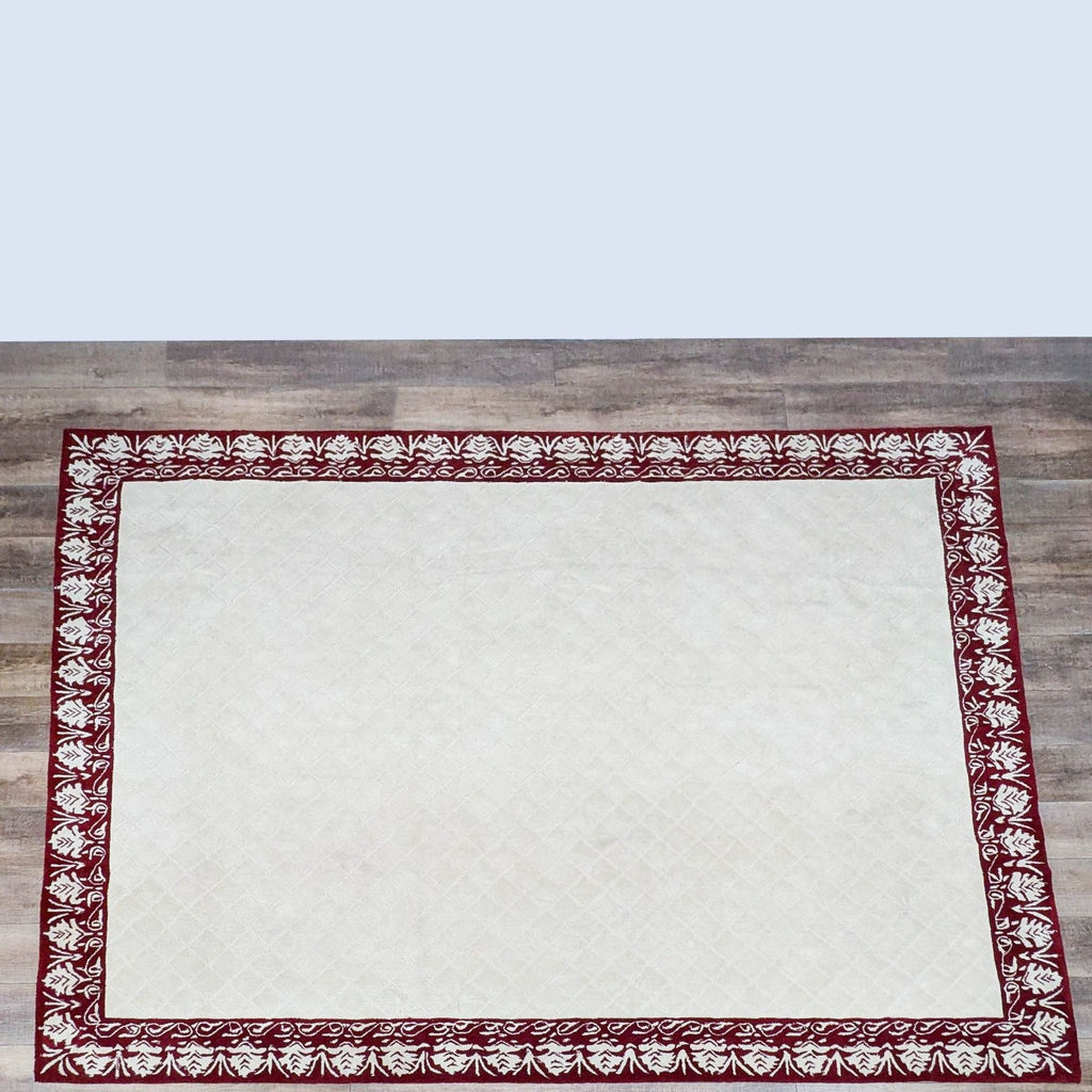 Hand-hooked Safavieh rug with red floral border on a cream background.
