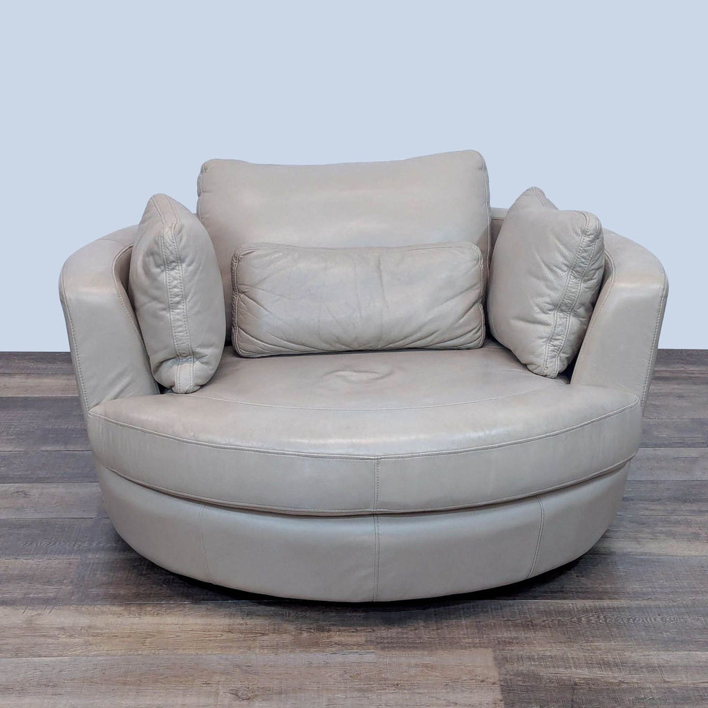 Round leather lounge chair with loose back pillows from Reperch.
