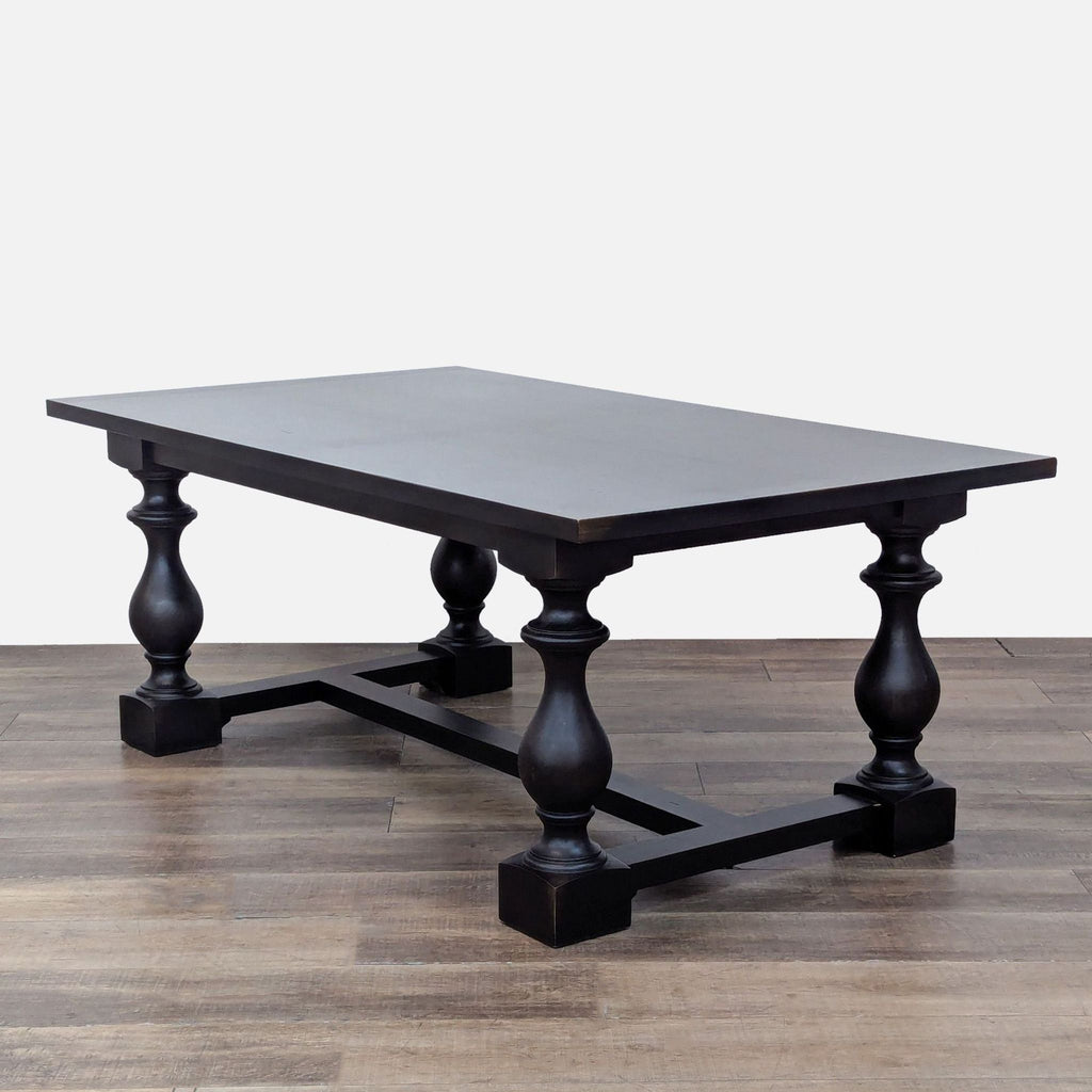 Side angle of a Restoration Hardware dining table, featuring a wood veneer top and turned baluster legs.